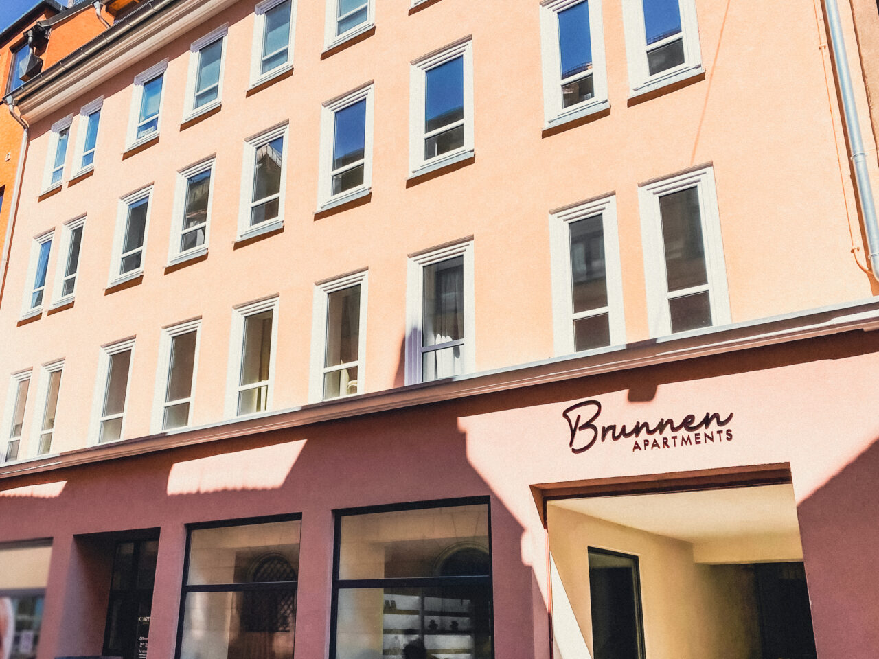 Fassade der Brunnen Apartments mit dem Schriftzug Brunnen Apartments über dem Eingang