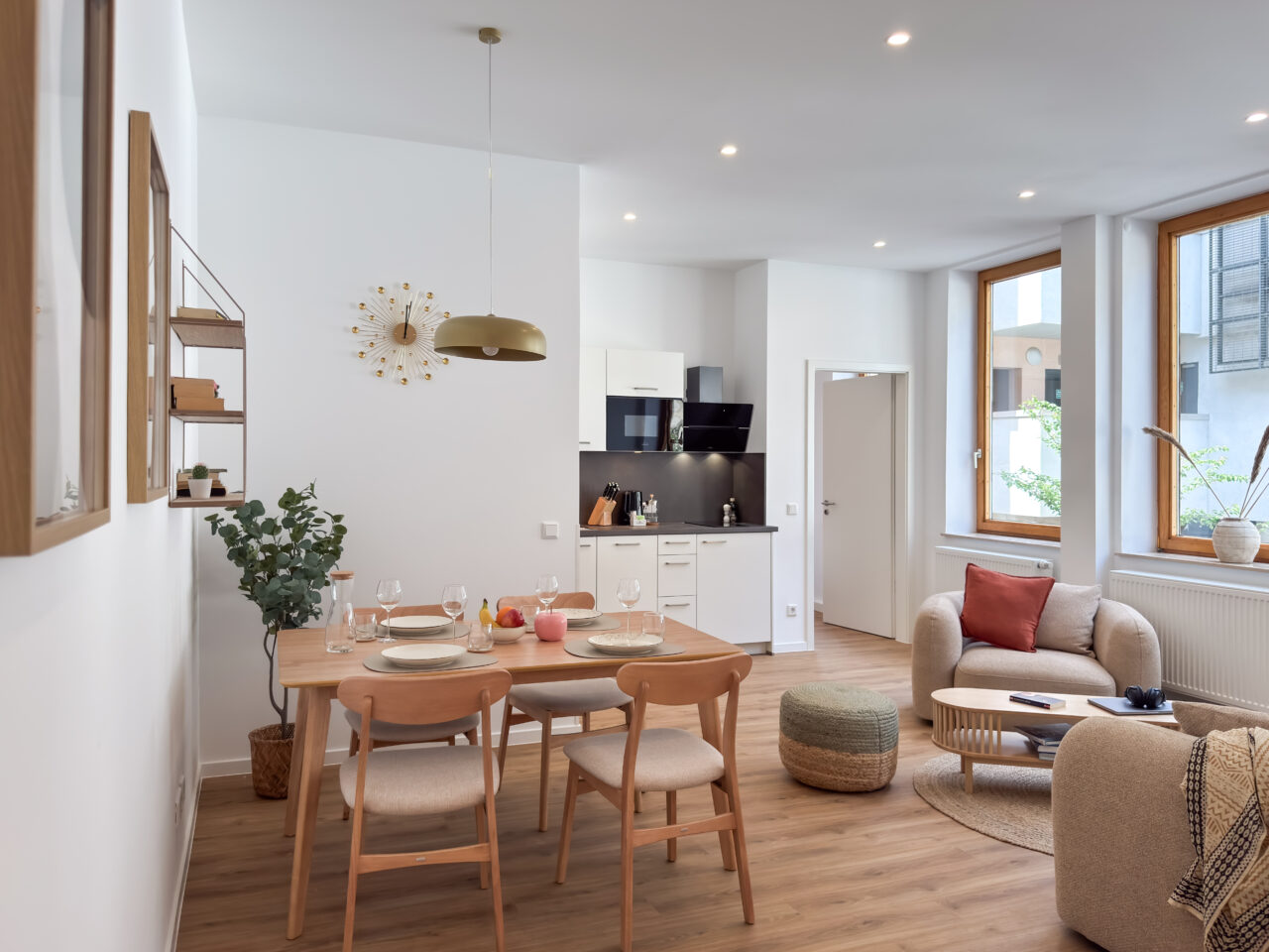 Esstisch aus Holz mit mehreren Stühlen in einem hellen Wohnraum